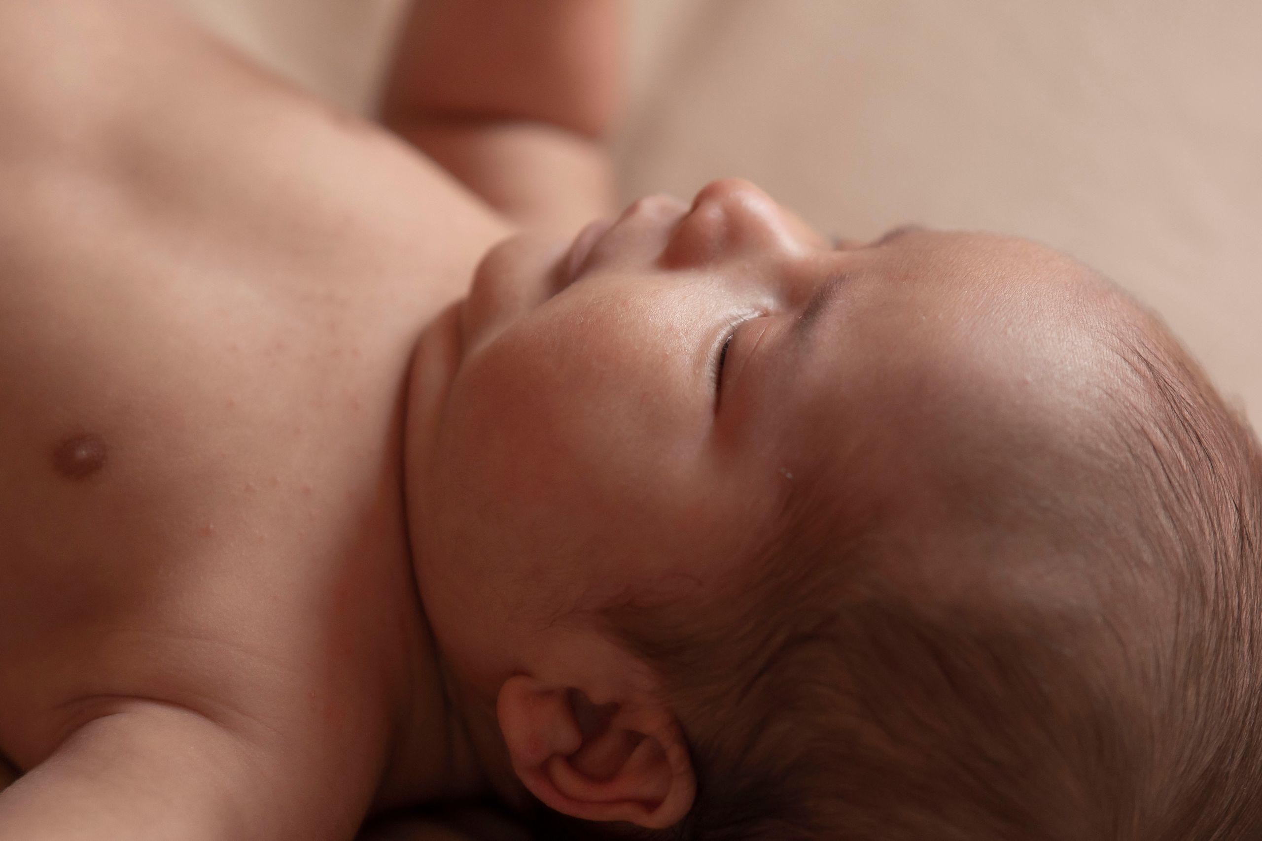 A serene close-up photograph capturing the peaceful innocence of a newborn baby sleeping.